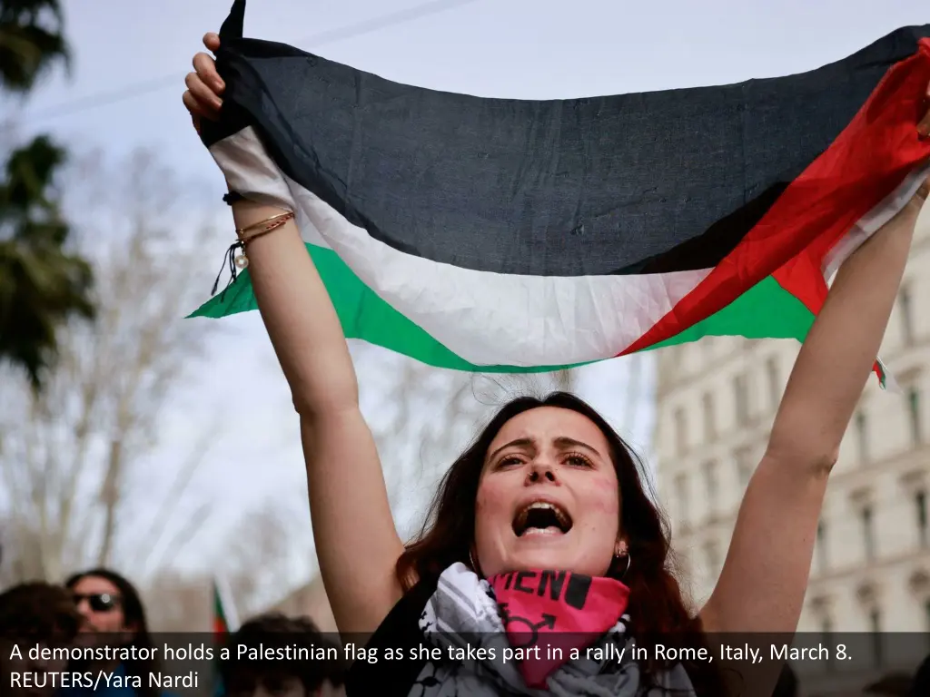 a demonstrator holds a palestinian flag