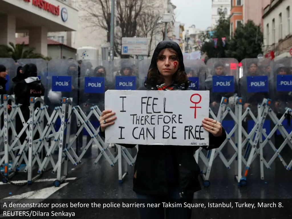 a demonstrator poses before the police barriers