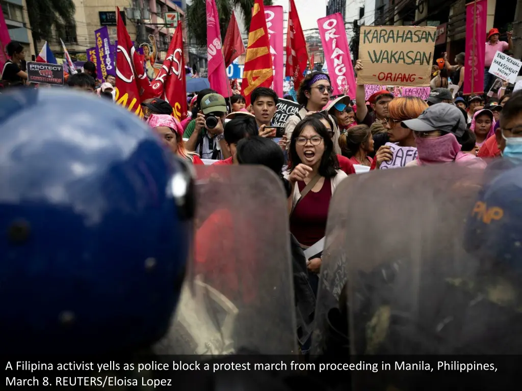 a filipina activist yells as police block