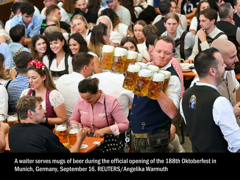 a waiter serves mugs of beer during the official