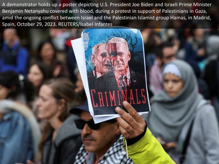 a demonstrator holds up a poster depicting
