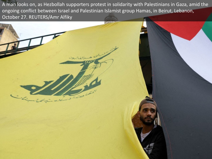 a man looks on as hezbollah supporters protest