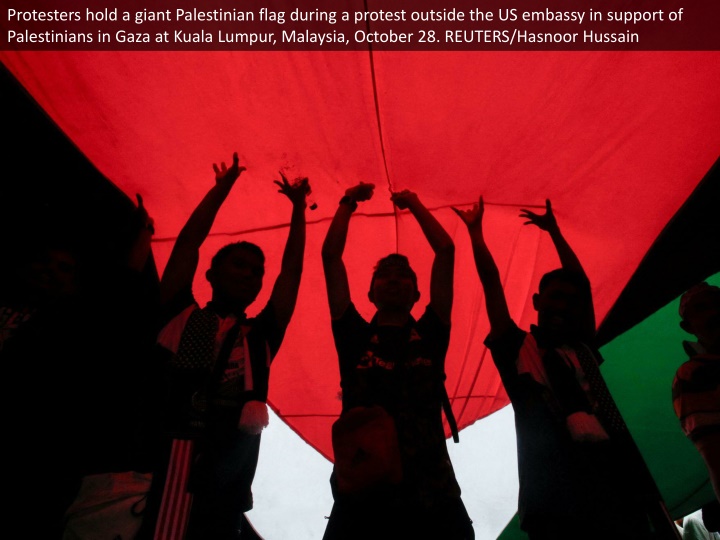 protesters hold a giant palestinian flag during